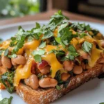 Cheesy Masala Beans on Toast is a delightful dish that beautifully marries the comforting essence of classic toast with the bold, vibrant flavors of Indian spices. This fusion recipe showcases the richness of mixed beans paired with the creamy indulgence of cheddar cheese, resulting in a dish that is not only satisfying but also bursting with flavor. Whether you're looking for a quick breakfast option, a hearty snack, or a light dinner, this recipe checks all the boxes. The combination of spices and cheese makes it an irresistible choice for anyone who appreciates a good comfort meal.