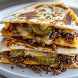 Exploring the delightful fusion of a smashburger and a quesadilla, this recipe offers a comforting meal that is as satisfying as it is flavorful. The Dreamy Smashburger Quesadillas are designed to cater to both burger enthusiasts and quesadilla lovers, delivering the best of both worlds in each bite. With a combination of gooey cheese, juicy beef, and zesty pickles, these quesadillas are sure to be a hit at any gathering or family dinner.