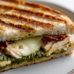 The Chicken Pesto Panini Delight is a simple yet delectable meal that encapsulates the essence of Italian cuisine. Combining tender chicken breast with vibrant basil pesto, this panini is a taste explosion wrapped between two slices of perfectly toasted ciabatta bread. The robust flavors of sun-dried tomatoes and rich mozzarella cheese meld beautifully, making each bite a satisfying experience. It's a quintessential lunch option, offering a gourmet feel without the fuss; ideal for anyone craving a quick yet flavorful meal.