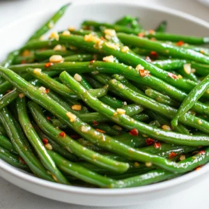 Exploring the delightful flavors of Garlic-Infused Buttered Green Beans brings a fresh and vibrant touch to any meal. This side dish, steeped in American culinary tradition, combines the crisp texture of green beans with the rich, savory allure of garlic butter, creating an irresistible accompaniment to a variety of main courses. The natural sweetness of green beans is beautifully contrasted by the aromatic garlic, making every bite burst with flavor.