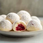 Raspberry Filled Almond Snowball Cookies embody the spirit of holiday baking with their delightful burst of raspberry jam encased in a buttery almond cookie. The combination of sweet and tart ensures each bite is a treat, making these cookies a festive favorite. They are simple enough to whip up on a cozy weekend or special family gathering, yet impressive enough to steal the spotlight on any dessert table.